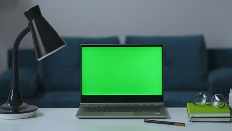 notebook-with-green-screen-for-chroma-key-technology-zooming-shot-on-table-in-living-room-remote-working-place-in-home-isolation-and-distance-during-pandemic